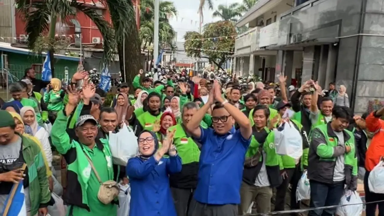 Anggota DPR RI Uya Kuya dan istrinya, Astrid Kuya selaku Legislator Jakarta, membagikan tunjangan hari raya (THR) dan juga beras ke ribuan OJOL dan warga di kawasan Tanah Kusir, Jakarta Selatan (Istimewa)