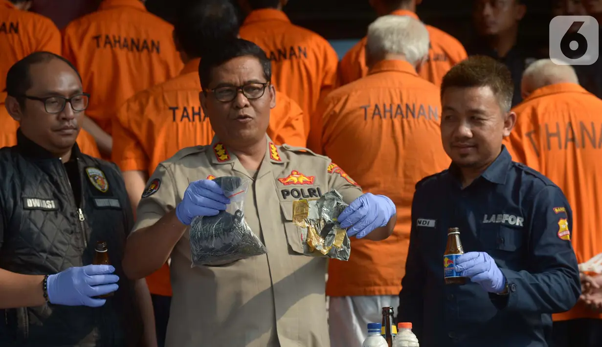Kabid Humas Polda Metro Jaya Kombes Pol  Argo Yuwono (tengah) menunjukkan barang bukti bom rakitan dan molotov saat rilis kasus rencana peledakan di Polda Metro Jaya, Jakarta (18/10). Polisi juga berhasil membekuk 21 tersangka. (merdeka.com/Imam Buhori)