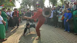 Warga menampilkan silat palang pintu saat Lebaran Orang Depok di Sawangan, Depok, Jawa Barat, Minggu (7/7/2019). Lebaran Orang Depok baru pertama kali diadakan acara tersebut untuk melestarrikan budaya dan sebagai ajang silaturahmi warga Depok. (Liputna6.com/Herman Zakharia)