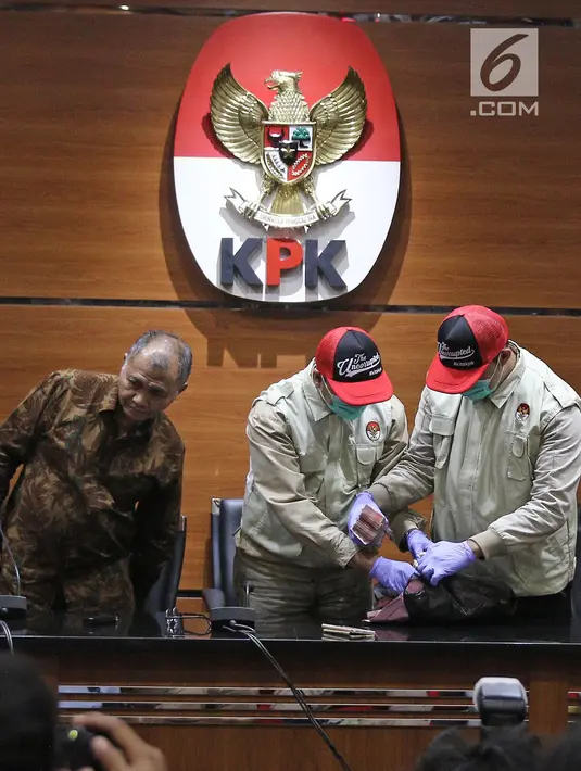 Penyidik KPK menunjukkan barang bukti uang Rp 100 Juta dari OTT Bupati Purbalingga disaksikan Ketua KPK Agus Rahardjo di Gedung Merah Putih KPK, Kuningan, Jakarta, Selasa (5/6). (Liputan6.com/Herman Zakharia)