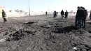 Sejumlah orang melihat  lokasi bom truk yang meledak di sekolah polisi di kota Zliten, wilayah barat Libya, Kamis (7/1). Belum ada yang mengaku bertanggung jawab terkait serangan bom yang menewaskan 50 orang tersebut. (AFP PHOTO/MAHMUD Turkia)