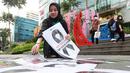 Seorang anggota komunitas Centennialz membentangkan poster di trotoar jalan dalam Aksi Duka 1 Juta Pita Hitam untuk Timnas Indonesia U-20 dan Piala Dunia U-20 di trotoar FX Sudirman, Jakarta, Jumat (31/3/2023). (Bola.com/M Iqbal Ichsan)