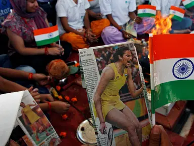 Warga saat melakukan ritual doa untuk atlet bulu tangkis mereka, P.V. Sindhu yang sedang mengikuti Olimpiade 2016 untuk mendapatkan medali emas di Chandigarh , India , 19 Agustus 2016. (REUTERS / Ajay Verma)