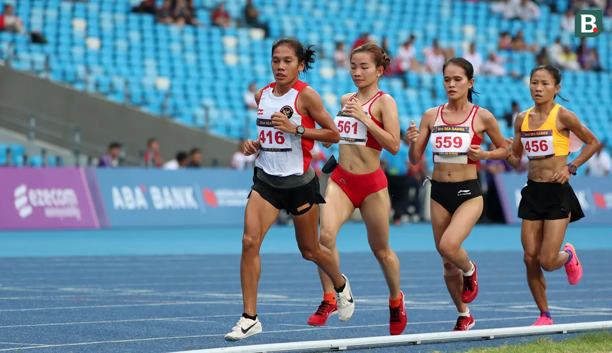 Reaksi pelari putri Indonesia, Odekta Elvina Naibaho (kiri) berkompetisi pada nomor lari 10.000 meter SEA Games 2023 di Stadion Morodok Techo National Stadium, Phnom Penh, Kamboja, Jumat (12/5/2023). Odekta meraih medali perunggu dengan catatan waktu 35 menit 31,03 detik sementara medali emas dan perak direbut dua atlet Vietnam, Thi Oanh Nguyen (35 menit 11,53 detik) dan Thi Hong Le Pham (35 menit 21,09 detik). (Bola.com/Abdul Aziz)