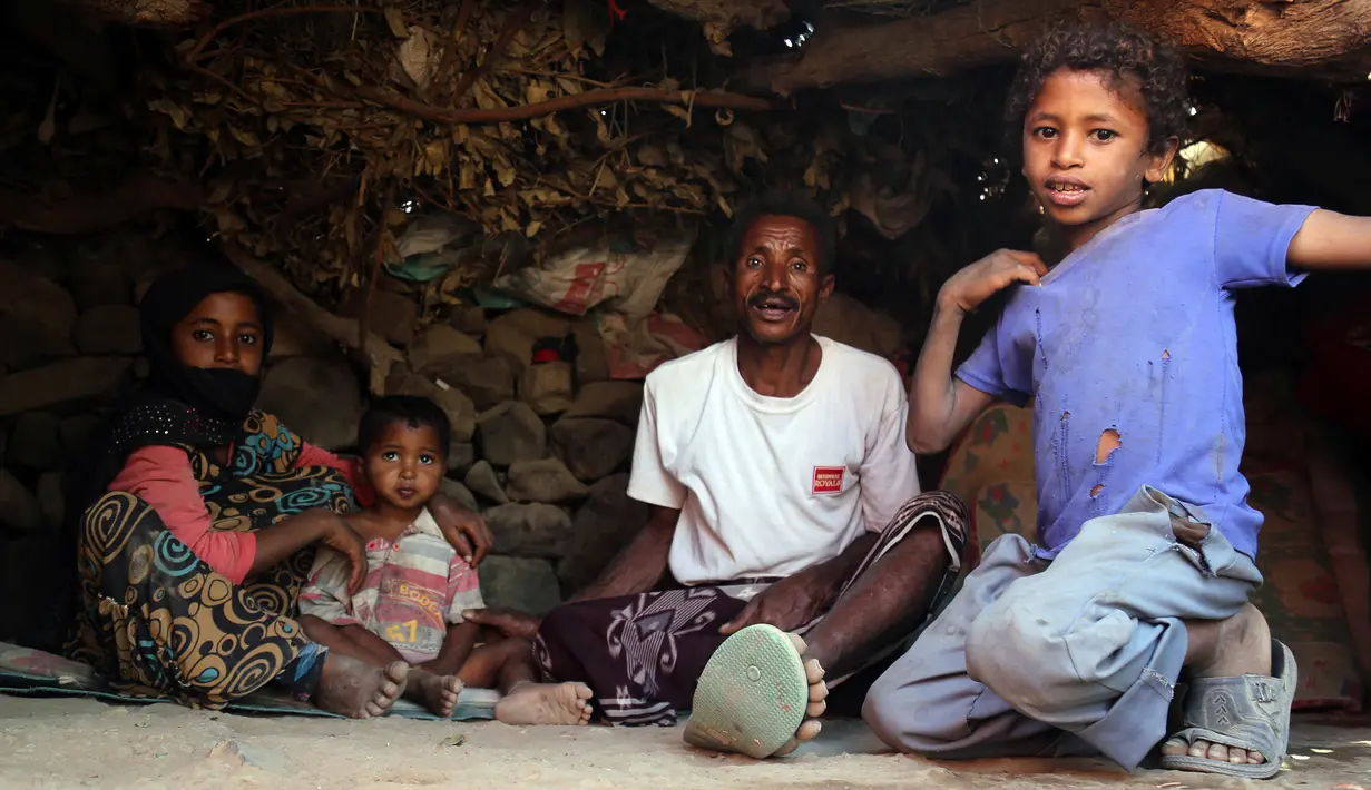 Salah satu keluarga duduk di depan gubuk mereka di kamp pengungsian Taez, Yaman (11/1). WHO mencatat sebanyak 2,1 juta orang telah terlantar akibat konflik yang terjadi di Yaman. (AFP Photo/Ahmad Al-Basha)