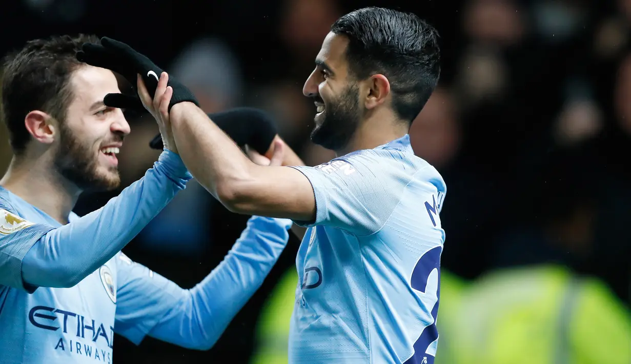 Gelandang Manchester City, Riyad Mahrez (kanan) berselebrasi dengan Bernardo Silva usai mencetak gol ke gawang Watford pada lanjutan Liga Inggris di stadion Vicarage Road (4/12). City menang tipis atas Watford 2-1. (AP Photo/Frank Augstein)