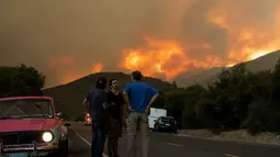 Warga berkumpul dan berbincang saat api membakar Hutan Nasional Angeles di California, Amerika Serikat, Rabu (12/8/2020). Kebakaran yang diberi nama Lake Fire tersebut terjadi di sekitar Danau Hughes. (AP Photo Ringo H.W. Chiu)