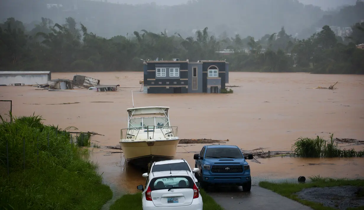 Sebuah rumah terendam banjir akibat Badai Fiona di Cayey, Puerto Rico, Minggu, 18 September 2022. Menurut pihak berwenang, tiga orang berada di dalam rumah dan dilaporkan telah diselamatkan. (AP Photo/Stephanie Rojas)