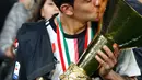Striker Juventus, Paulo Dybala mencium Piala Liga Italia Serie A usai menjuarainya untuk ke-33 kalinya di Stadion Allianz, Turin (19/5/2019). Juventus berhasil mengunci titel juara Liga Italia 2018/2019. (AP Photo/Antonio Calanni)