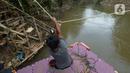 Seorang anak menggunakan perahu eretan di sungai Ciliwung, Jakarta, Selasa (3/11/2020). Perahu eretan di sungai Ciliwung masih bertahan sebagai penghubung Jakarta Timur dan Jakarta Selatan Selatan. (merdeka.com/Imam Buhori)