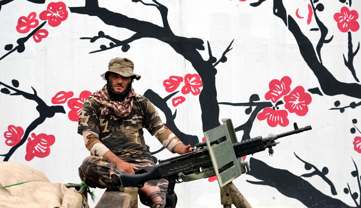 Seorang pasukan Taliban menggunakan senjatanya saat merayakan satu tahun sejak mereka merebut Kabul di depan Kedutaan Besar AS di Kabul, Afghanistan, Senin (15/8/2022). Taliban memperingati tahun pertama pengambilalihan kekuasaan setelah pemerintah negara yang didukung barat itu melarikan diri dan militer Afghanistan hancur dalam menghadapi serangan Taliban. (AP Photo/Ebrahim Noroozi)