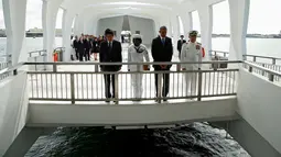 Presiden AS, Barack Obama dan PM Jepang, Shinzo Abe menundukan kepala usai berpartisipasi dalam upacara peletakan karangan bunga di atas kapal Memorial USS Arizona di Pearl Harbor, Hawaii, (27/12). (REUTERS/Kevin Lamarque)