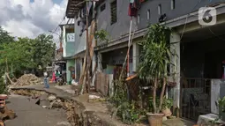 Seorang pria mengambil gambar ruas jalan yang ambles di Jalan Kesatria, Matraman, Jakarta, Selasa (3/3/2020). Amblesnya ruas jalan mengakibatkan akses lalu lintas lumpuh total dan tidak bisa dilewati kendaraan roda dua maupun roda empat. (Liputan6.com/Herman Zakharia)