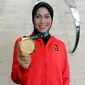 Atlet Taekwondo Defia Rosmaniar menunjukkan medali emas Asian Games 2018 saat berkunjung ke SCTV, Senayan City, Jakarta, Senin (20/8). Kunjungannya tersebut untuk melakukan wawancara. (Liputan6.com/Johan Tallo)