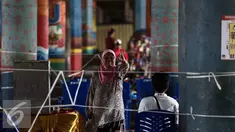Seorang warga menunjukan jarinya usai menggunakan hak pilihnya dalam Pilkada DKI Jakarta dengan melakukan pencoblosan di TPS 21 di bawah kolong jembatan tol akses Bandara, Petak Asem, Jakarta, Rabu (15/2). (Liputan6.com/Faizal Fanani)