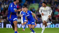 Jude Bellingham dari Real Madrid beraksi di depan Alex Sola dari Getafe saat pertandingan sepak bola La Liga antara Getafe dan Real Madrid di Getafe, Spanyol, Minggu, 19 Oktober 2025. (Foto AP/Manu Fernandez)