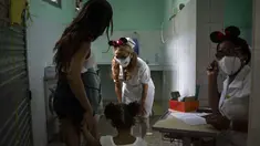 Perawat menyapa seorang anak yang tiba bersama ibunya untuk menerima dosis vaksin COVID-19 Soberana-02, di Havana, Kuba, Kamis (17/9/2021). Pemerintah Kuba memulai vaksinasi Covid-19 bagi anak-anak berusia 2 tahun dengan vaksin buatan dalam negeri. (AP Photo/Ramon Espinosa)