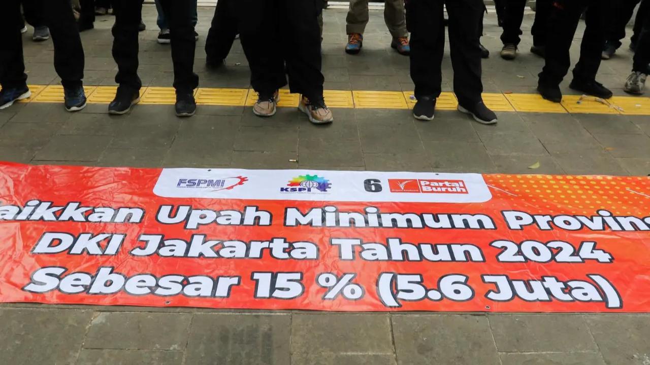 Massa demonstran membentang spanduk kenaikan upah saat menggelar aksi unjuk rasa di depan Balai Kota DKI Jakarta, Selasa (28/11/2023)