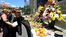 Wisatawan asing menaburkan bunga di Monumen Ground Zero Bali di kawasan Kuta, Bali (12/10). Mereka datang dan menaburkan bunga untuk memperingati tragedi bom Bali 2002. (AFP Photo/Sonny Tumbelaka)