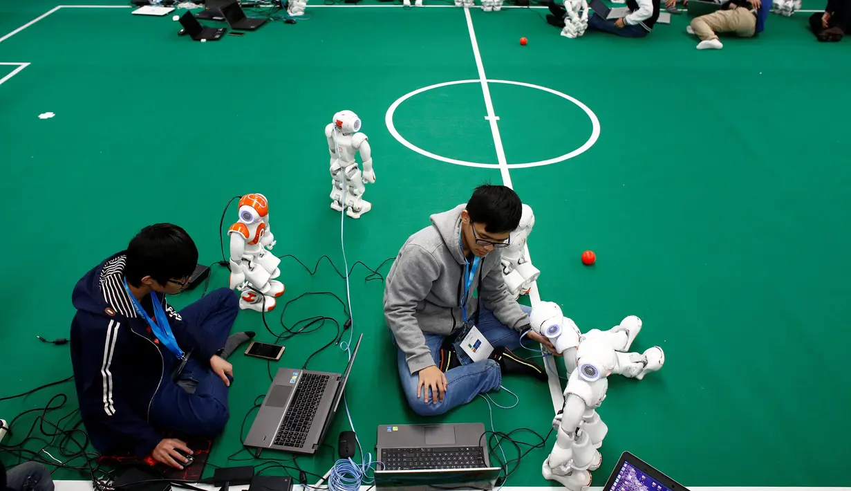 Peserta memprogram NAO Robot yang dipersiapkan untuk kompetisi sepak bola robot di Konferensi Robot Dunia, WRC 2016 di Beijing, Tiongkok (21/10). Selain pameran robot, perhelatan ini juga diisi dengan berbagai kompetisi robot. (Reuters/Thomas Peter)