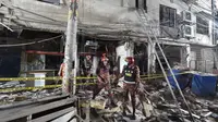 Petugas damkar memeriksa tempat kejadian setelah dugaan ledakan gas di jalanan ramai di Moghbazar, Dhaka, Bangladesh, Minggu (27/6/2021). Setidaknya tujuh orang tewas dan lebih dari 50 lainnya terluka dalam ledakan yang terjadi di lantai bawah gedung tiga lantai tersebut. (Munir Uz zaman/AFP)