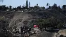 Petugas pemadam kebakaran mencari sisa titik api di lingkungan perumahan yang hancur akibat kebakaran hutan yang disebabkan oleh angin di Camarillo, California pada tanggal Jumat 8 November 2024. (Patrick T. Fallon/AFP)