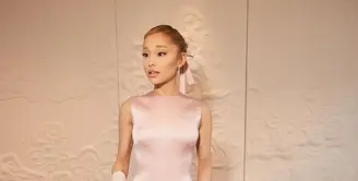 Ariana Grande menghadiri Upacara Pembukaan pada 26 Juli dengan gaun sutra berpinggang rendah warna merah muda Glinda karya Thom Browne. [@arianagrande].