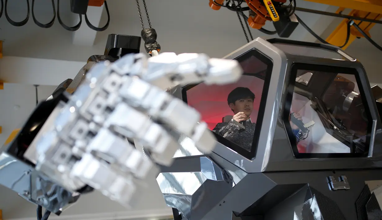  Seorang karyawan berada di dalam ruang kontrol mengerakan tangan robot berawak  "METHOD-2" selama demonstrasi di Gunpo, Korea Selatan, (27/12). Robot raksasa ini memiliki ketinggian 4 meter. (Reuters/Kim Hong-Ji)