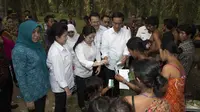 Presiden Joko Widodo  bersama Menko Pembangunan Manusia dan Kebudayaan Puan Maharani membagikan Kartu Indonesia Sehat (KIS) kepada warga Suku Anak Dalam (Orang Rimba) saat melakukan kunjungan ke Desa Bukit Suban, Air Hitam, Jambi, Jumat (30/10/2015). 