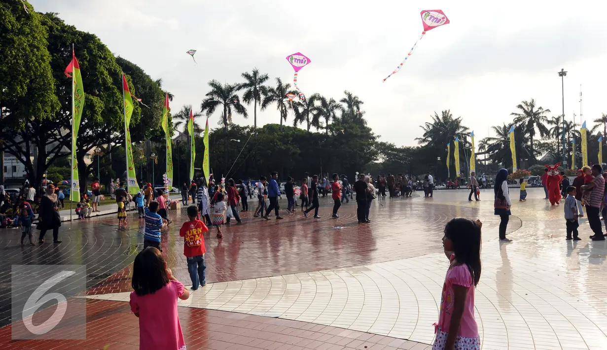 Sejumlah anak bermain layang layang di Lapangan Monumen Tugu Pancasila TMII, Jakarta, Jumat (8/7). TMII masih menjadi lokasi favorit warga menghabiskan libur hari raya. (Liputan6.com/Helmi Fithriansyah)