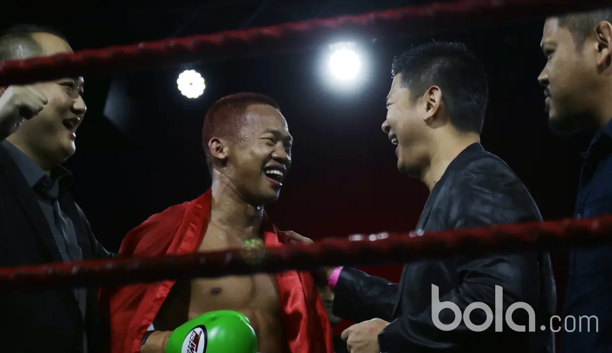 Ekspresi senang Daud Yordan dan promotornya, Raja Sapta Oktohari (2kanan) usai laga melawan Campee Phayom sehingga di OCBC Arena, Singapura, Sabtu (25/3/2017).  Kemanangan ini menjadi batu loncatan Daud untuk laga berikut. (Bola.com/Nicklas Hanoatubun)