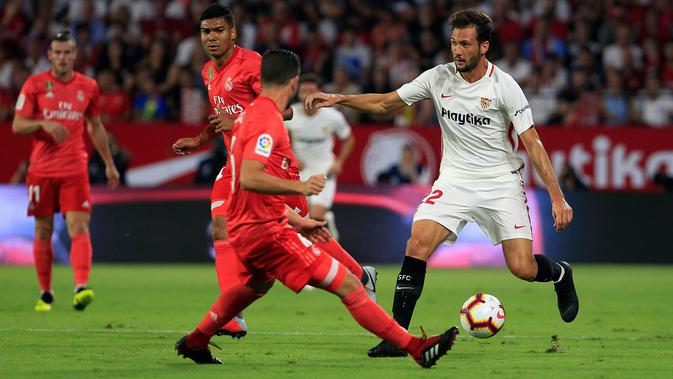 Pemain Sevilla, Franco Vazquez membawa bola dari kawalan bek Real Madrid Nacho saat bertanding pada lanjutan La Liga Spanyol di stadion Sanchez Pizjuan (26/9).  Sevilla menang telak 3-0 atas Madrid. (AP Photo/Miguel Morenatti)