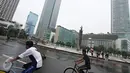 Dua warga bersepeda di kawasan Car Free Day, Jakarta, Minggu (28/2/2016). Hujan yang mengguyur Ibukota sejak semalam hingga pagi membuat kawasan CFD sepi pengunjung. (Liputan6.com/Immanuel Antonius)