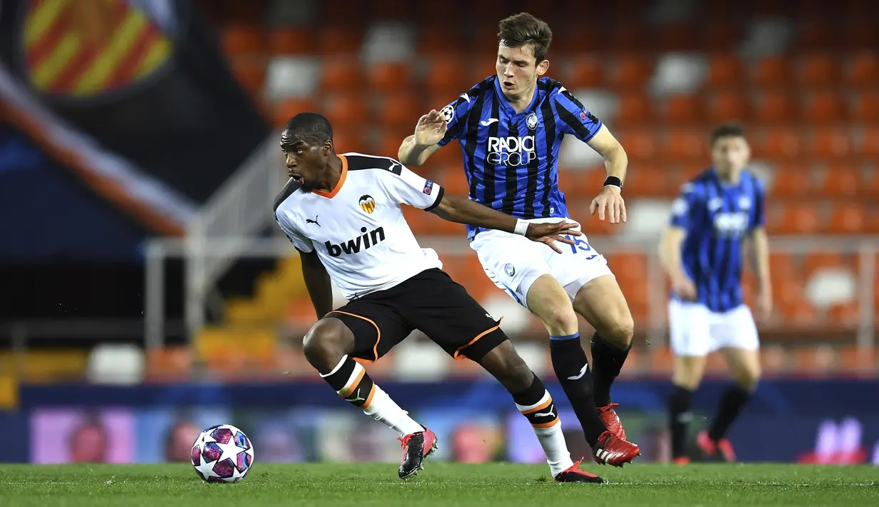 Gelandang Valencia, Geoffrey Kondogbia membawa bola dari kawalan pemain Atalanta, Marten de Roon  pada pertandingan leg kedua babak 16 besar Liga Champions di Mestalla, Spanyol (10/3/2020). Atalanta menang 4-3 atas Valencia dan lolos ke perempat final Liga Champions. (UEFA via AP)