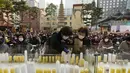 Seorang wanita menyalakan lilin untuk mendoakan kesuksesan anaknya dalam ujian masuk perguruan tinggi di kuil Buddha Jogyesa, Seoul, Rabu (17/11/2021). Sekitar 500.000 siswa SMA di Korea Selatan diperkirakan akan mengikuti Tes Kemampuan Skolastik Perguruan Tinggi. (AP Photo/Ahn Young-joon)