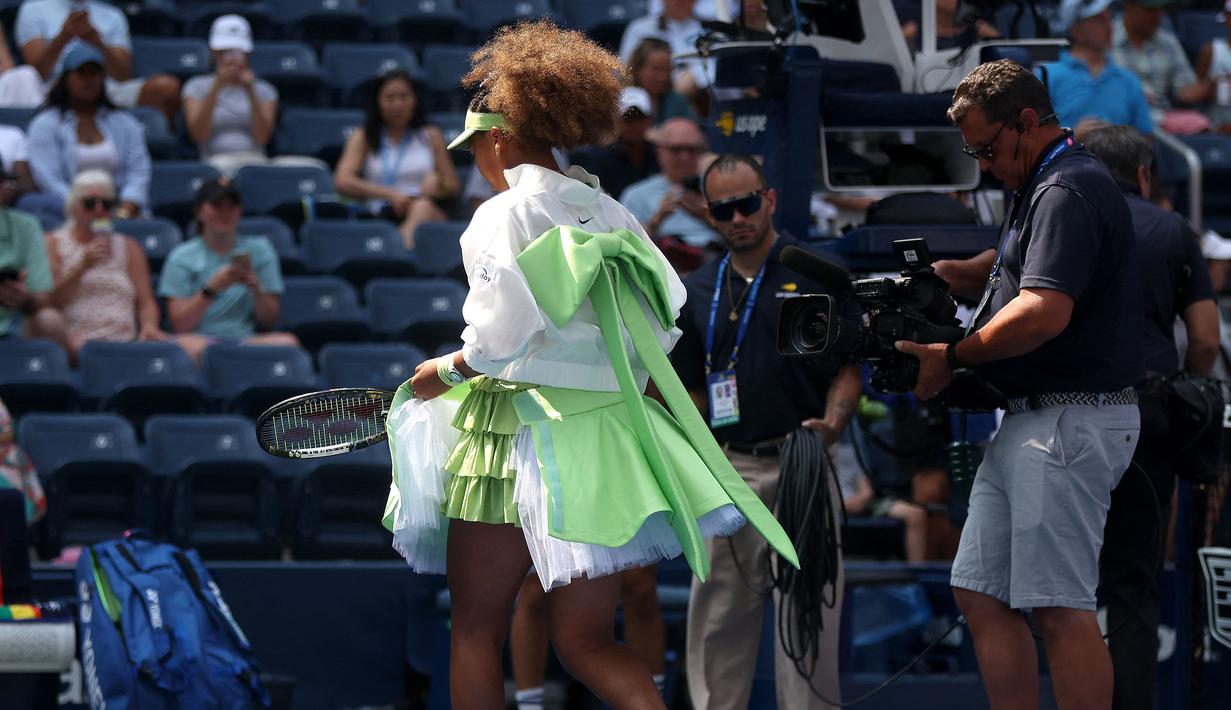 Petenis Jepang, Naomi Osaka mengenakan pakaian yang mewah saat melakukan pemanasan sebelum laga putaran pertama melawan petenis Latvia, Jelena Ostapenko pada laga putaran pertama Amerika Open 2024 di USTA Billie Jean King National Tennis Center, New York, Selasa (27/08/2024). (AFP/Mike Stobe)