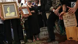 Sanak keluarga dan kerabat membawa potret gambar artis senior RMH Heroe Siswanto atau dikenal Sys NS saat pemakamannya di TPU Jeruk Purut, Jakarta, Selasa (23/1). (Liputan6.com/ Herman Zakharia)