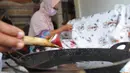 Warga menyelesaikan pembuatan batik di sentra batik Depok Tradjumas, Kamis (24/2/2022). Produksi Batik Depok kembali menggeliat setelah diberlakukannya pembelajaran tatap muka (PTM) Kota Depok di mana murid SD dan SMP menggunakan seragam batik produksi mereka. (merdeka.com/Arie Basuki)
