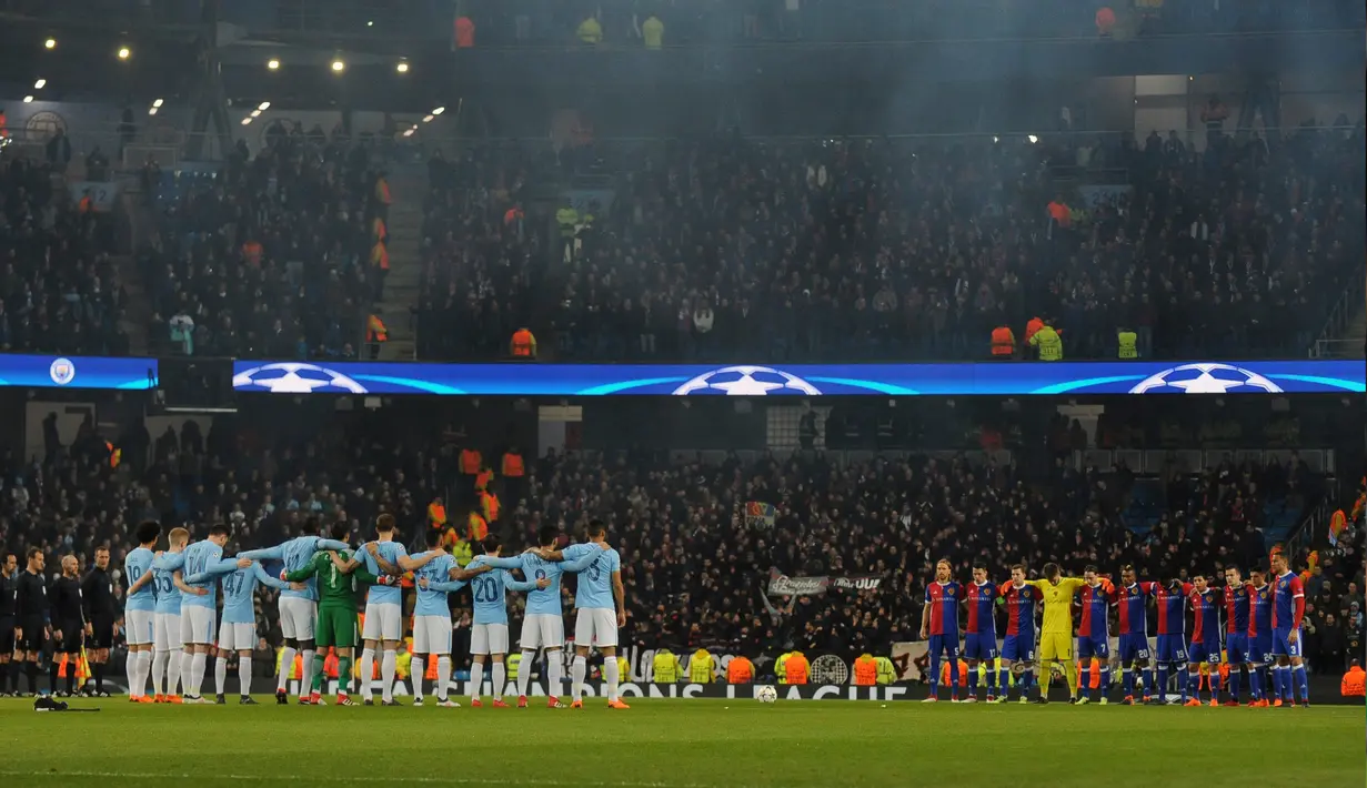 Pemain Manchester City dan FC Basel mengheningkan cipta untuk menghormati kapten Fiorentina Davide Astori yang telah meninggal, sebelum dimulainya Liga Champions leg kedua  di Stadion Etihad, Manchester (7/3). (AP Photo / Rui Vieira)