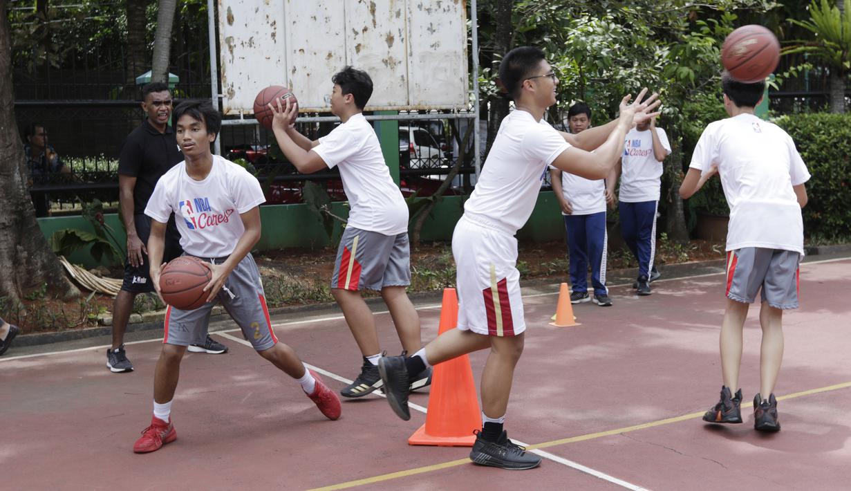 Sejumlah siswa mengikuti pelatihan oleh Legenda NBA, Jason Richardson, di SMA 82 Jakarta, Kamis (28/3). Kunjungan peraih dua gelar juara kontes slamdunk NBA tersebut merupakan bagian dari rangkaian program Jr NBA. (Bola.com/M Iqbal Ichsan)