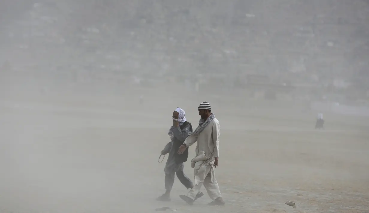 Pria Afghanistan berjalan saat badai pasir di pinggiran Kabul, Afghanistan (25/8/2020). Sebuah badai pasir hebat melanda Kabul. Badai menyebabkan jarak pandang jadi berkurang. (AP Photo / Rahmat Gul)