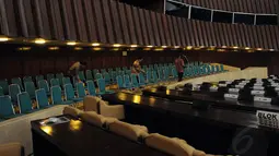 Sejumlah staff kesekretariatan membenahi deretan kursi yang ada di dalam ruang sidang utama di gedung DPR RI, (8/8/2014). (Liputan6.com/Faisal R Syam)