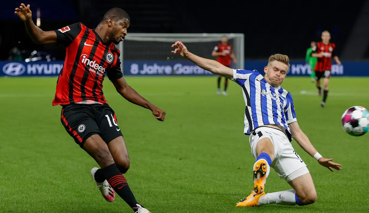 Bek Eintracht Frankfurt, Almamy Toure, berebut bola dengan bek Hertha Berlin, Niklas Stark, pada laga lanjutan Liga Jerman di Olympiastadion, Sabtu (26/9/2020) dini hari WIB. Frankfurt menang 3-1 atas Hertha Berlin. (AFP/Odd Andersen)