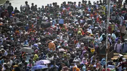 Orang-orang menunggu untuk menaiki kapal feri menuju kampung halaman menjelang perayaan Idul Fitri di tengah pandemi Covid-19 di Munshiganj, Bangladesh pada 9 Mei 2021. Ratusan orang bergegas untuk pulang ke rumah sehingga dapat berkumpul dengan keluarga pada momen Lebaran. (Munir Uz zaman/AFP)