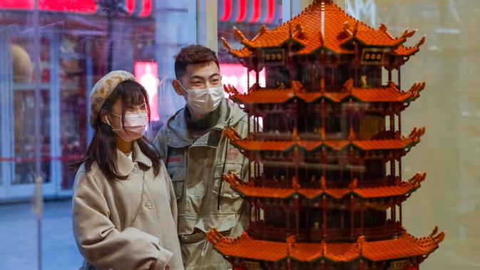 Orang-orang berhenti di salah satu toko di sebuah jalan kawasan perniagaan di Wuhan, Provinsi Hubei, China tengah, pada 30 Maret 2020. Jalan-jalan kawasan perniagaan di Wuhan kembali ramai seiring meredanya wabah COVID-19. (Xinhua/Shen Bohan)