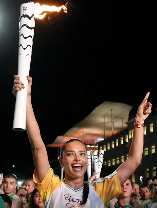 Senyum semringah supermodel Adriana Lima ketika membawa obor pada malam penyambutan Olimpiade Rio 2016 di Maua Square Rio de Janeiro, Brasil, Kamis (4/8). (REUTERS / Pilar Olivares)