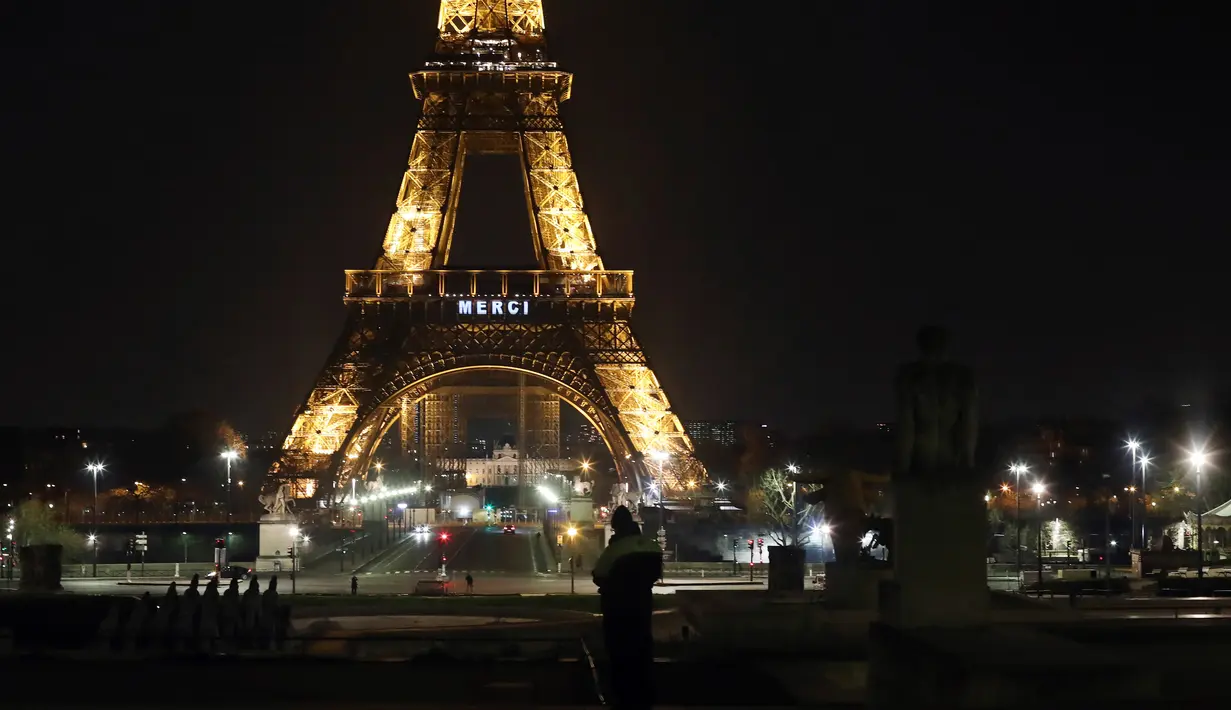 Kata "Merci atau terima kasih terpampang di Menara Eiffel, Paris, Jumat (27/3/2020). Menara Eiffel menyala untuk menampilkan pesan dukungan dan terima kasih kepada tenaga kesehatan di Prancis yang berada di garda depan memerangi pandemi COVID-19.  (AP/Thibault Camus)