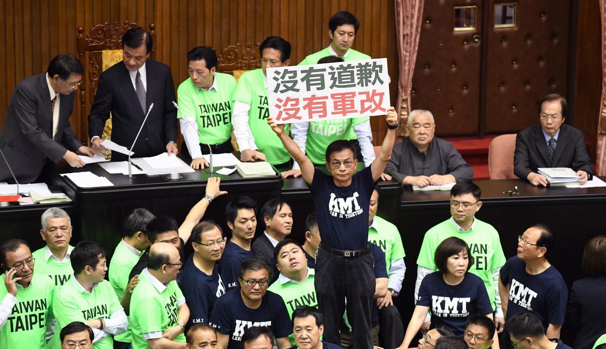 Anggota Kuomintang (KMT) menunjukkan poster saat melakukan protes di Parlemen di Taipei (20/4). Para legislator Taiwan tersebut bentrok saat membahas rancangan undang-undang untuk mereformasi sistem pensiun militer. (AFP Photo/Sam Yeh)