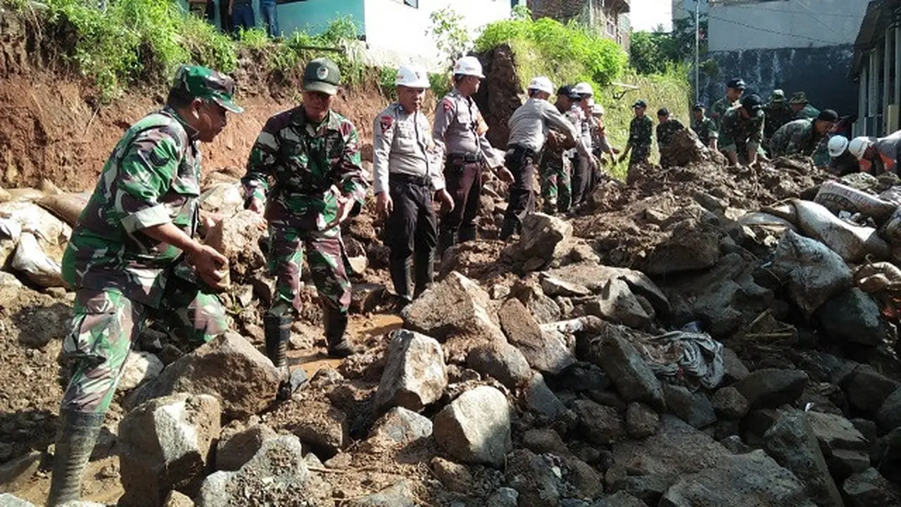 Petugas dari Satbrimob Polda Jabar, TNI, dan BPBD Kabupaten Bandung mulai memperbaiki tembok penahan tebing (TPT) anak sungai Cipanjalu yang jebol di Komplek Jati Endah Regency pada Sabtu (9/2/2019).