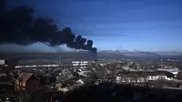 Asap hitam mengepul dari bandara militer di Chuguyev, dekat Kharkiv, 24 Februari 2022. Presiden Rusia Vladimir Putin mengumumkan operasi militer di Ukraina. (Aris Messinis/AFP)